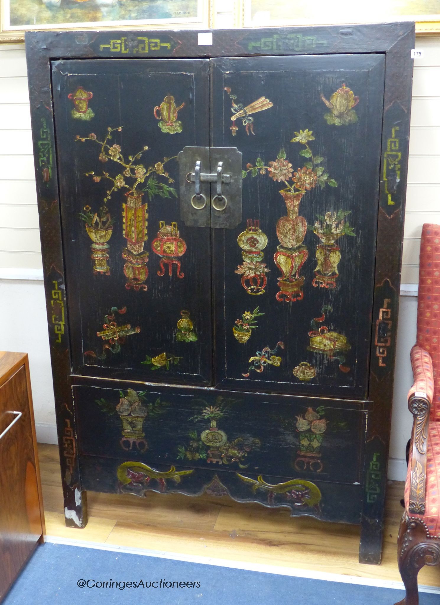 A Tibetan black and polychrome painted two door cabinet, width 115cm, depth 49cm, height 174cm